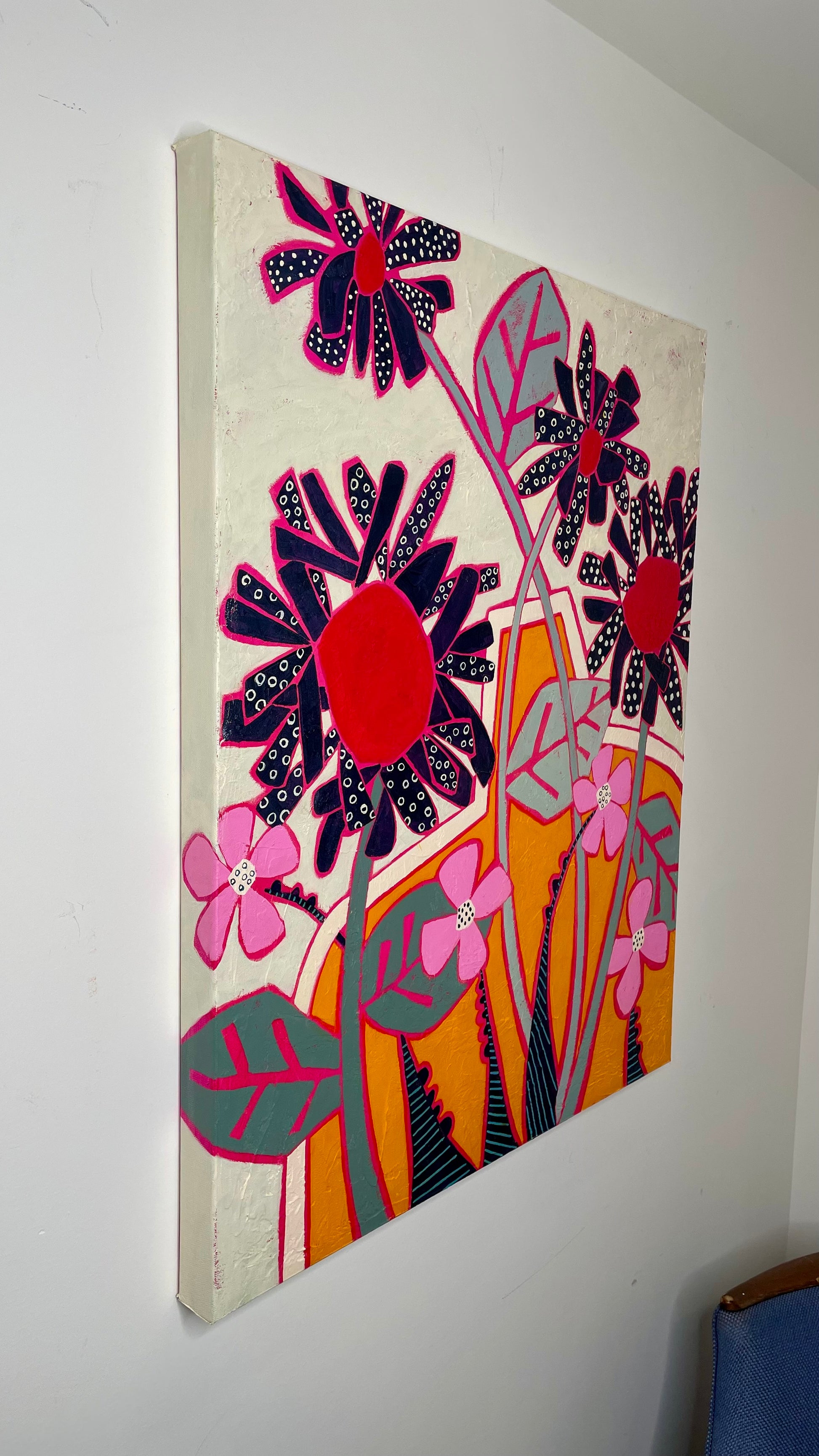 Side view of abstract floral painting on canvas showing depth and painted edges, black daisies and orange vase