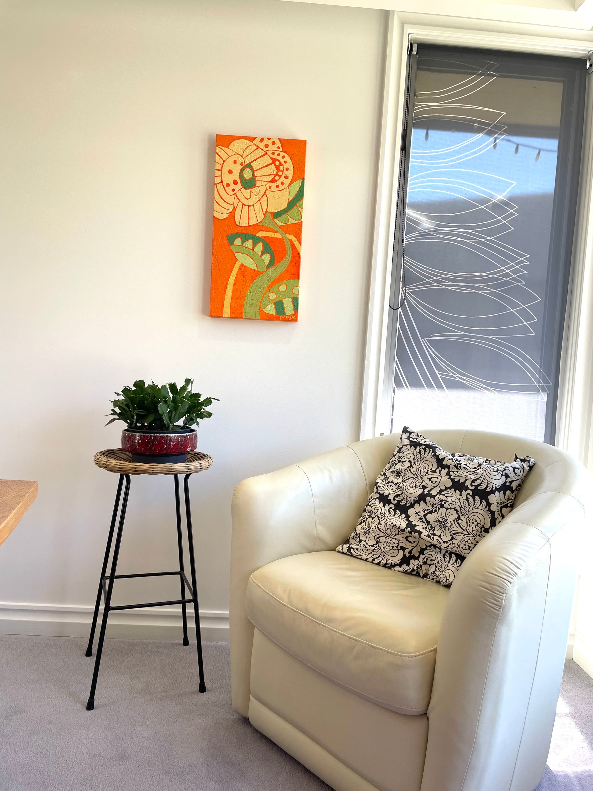 colorful abstract floral painting in a modern neutral room adding bold orange and green focal point